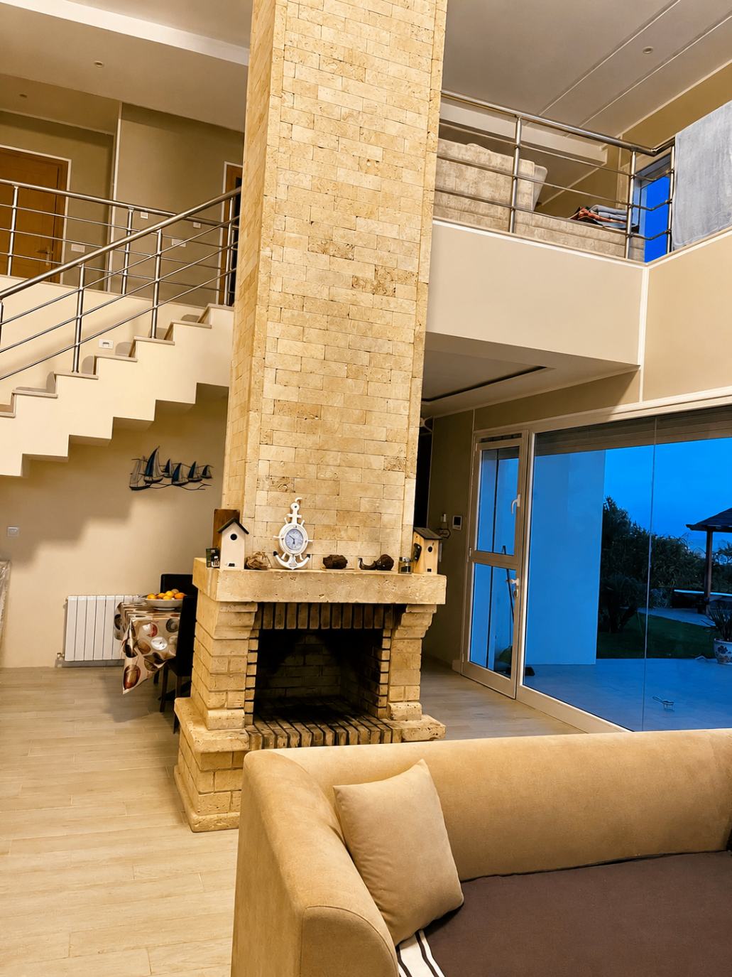 Double height salon with stone fireplace and staircase