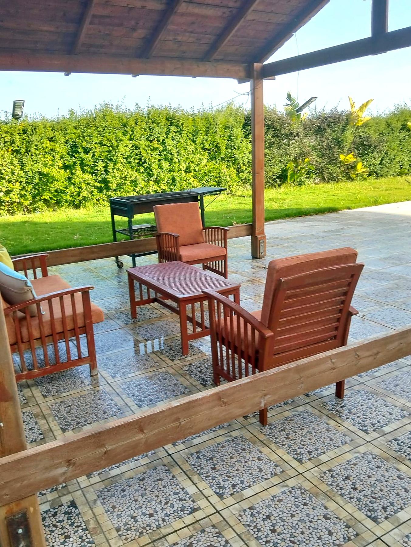 Shaded pergola terrace with lounge chairs and barbecue